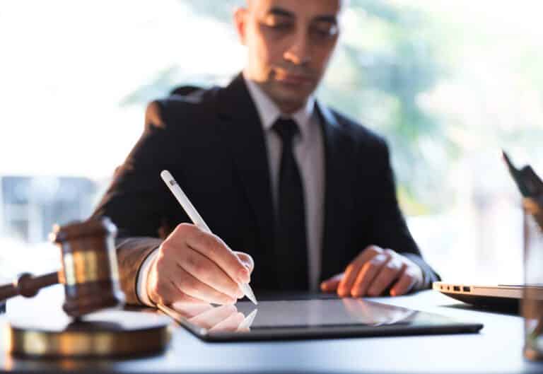 Hombre de negocios firmando un documento legal electrónico en una tableta digital