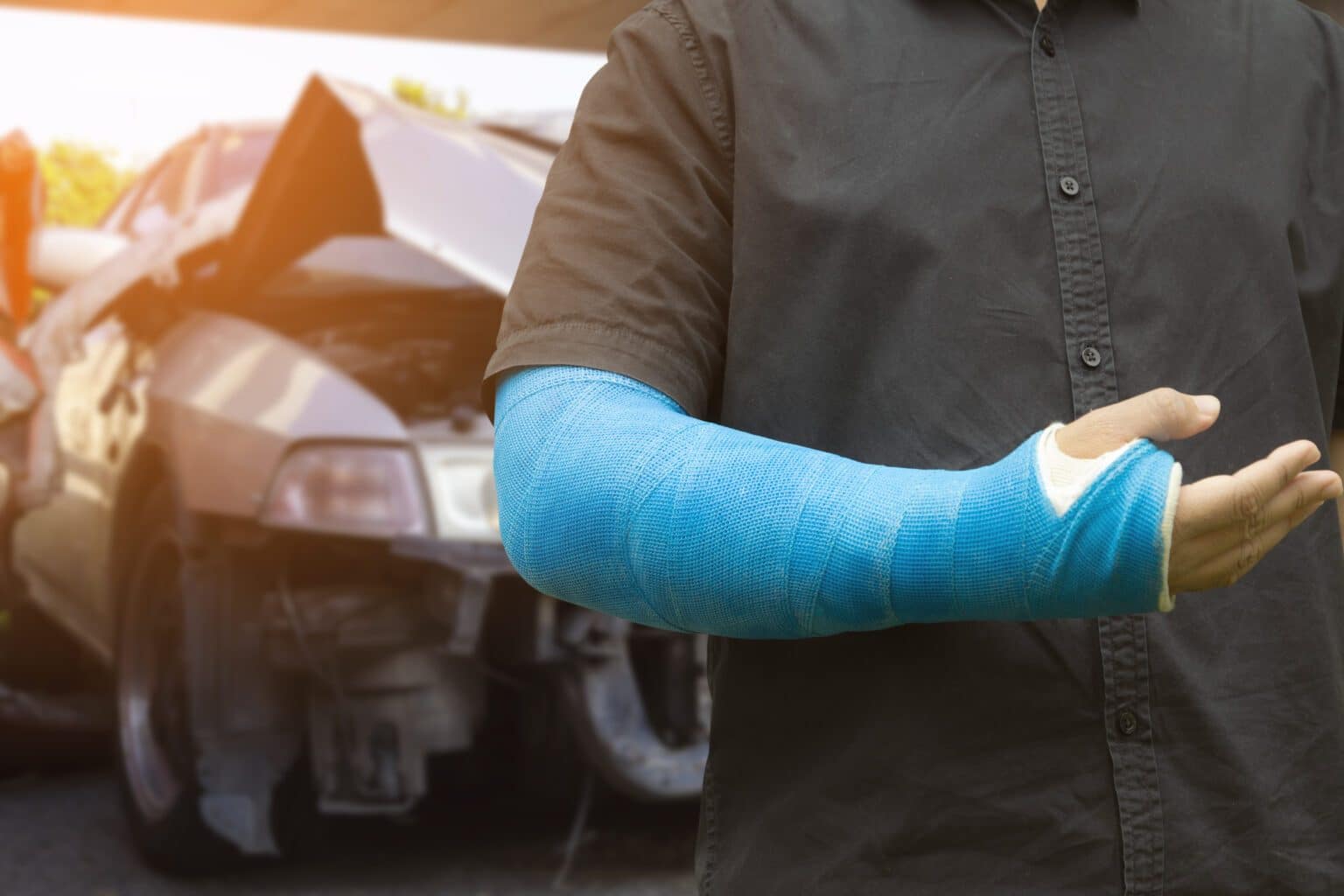 Asian men wear cloth splint on arm to treat car accident injuries.