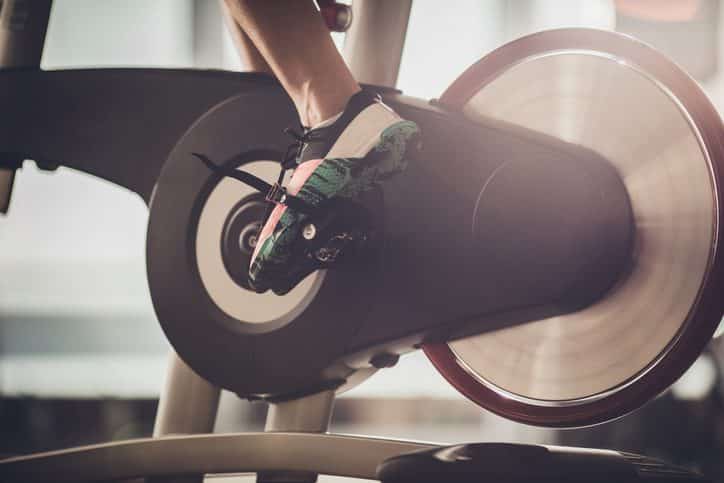 Unrecognizable athlete having a exercising class on stationary bike in a gym.